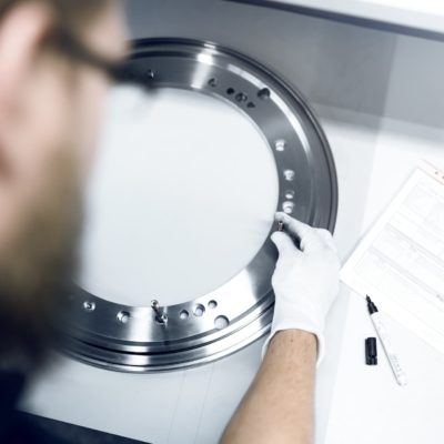Mitarbeiter von GTR Beschaffungsspezialist für Gussbauteile überprüft Qualität Ring und Schrauben